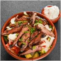 Komkommer, tomaat, sla, reepjes gekruide ossenhaas en saus naar keuze